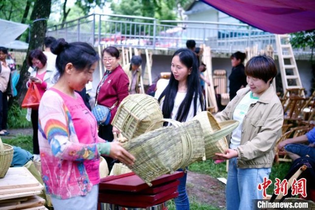 图为游客在挑选手工竹篮。　焦汉平 　摄