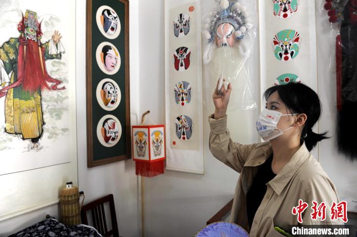 图为市民在陈耀武的秦腔脸谱工作室拍照留念。　高铖 摄