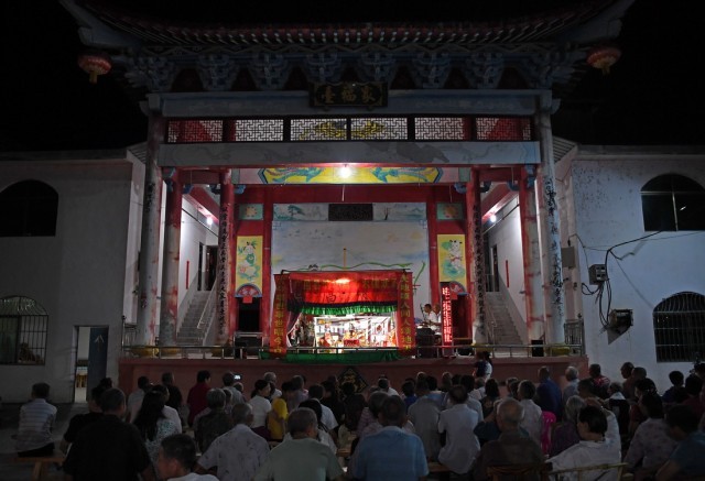 在江西省广昌县塘坊镇大株村，村民们在观看木偶戏演出（8月10日摄）。