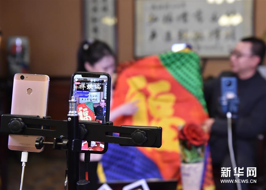 4月6日,瑞蚨祥工作人员在网络直播中展示产品.新华社发(陈钟昊摄)