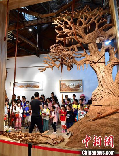 图为小学生们在福州素上软木艺术创新工作室展厅参观展示的软木画作品。　张斌 摄