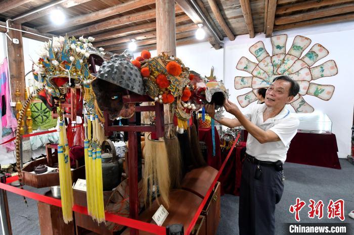 图为欧成斌正在介绍闽剧展示馆里的收藏品。 图为欧成斌正在介绍闽剧展示馆里的收藏品。
